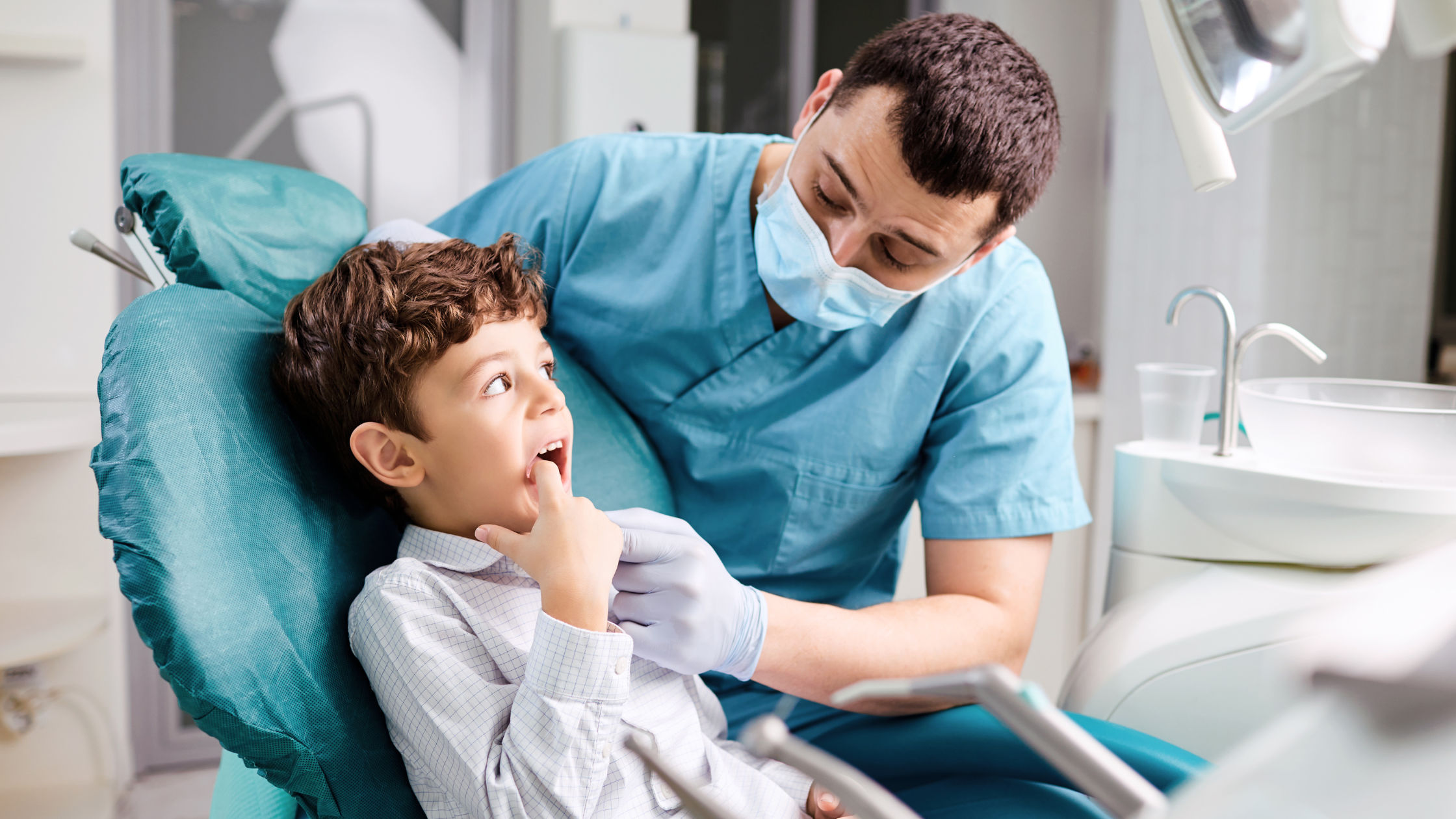 A smiling child sitting in a dental chair at Gravity Dental Poly Clinic in Dubai, showing a fun and stress-free kids dentist experience.