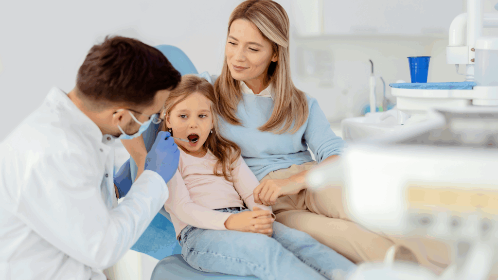 A pediatric dentist at Gravity Dental Poly Clinic in Dubai checks a toddler’s teeth during their first dental visit, promoting early oral health habits.