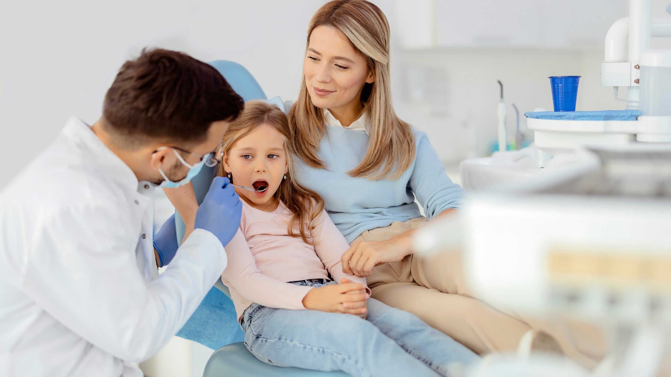 A pediatric dentist at Gravity Dental Poly Clinic in Dubai checks a toddler’s teeth during their first dental visit, promoting early oral health habits.