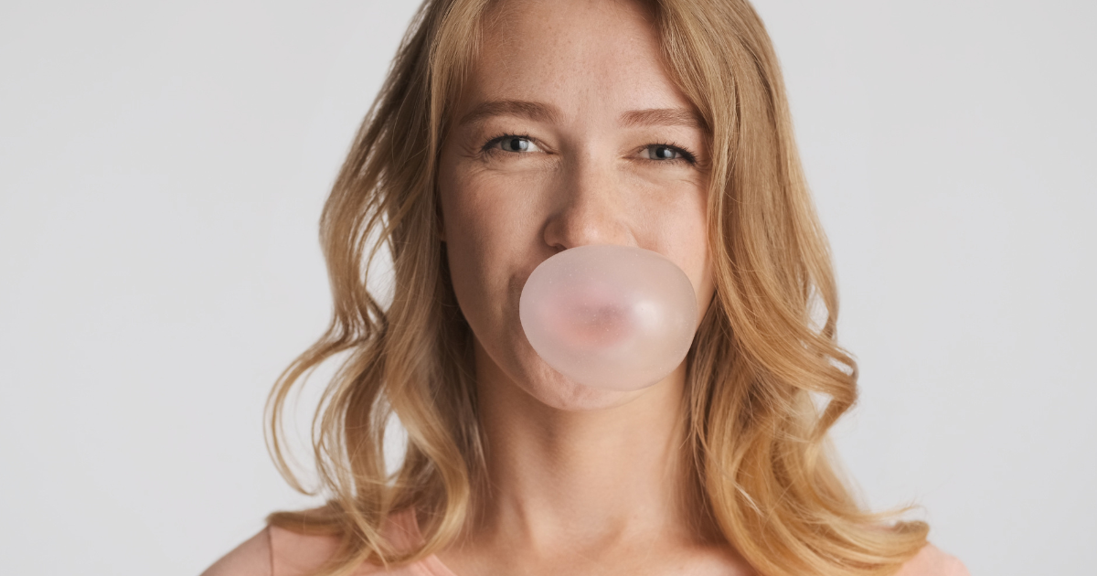 Person chewing sugar-free gum for better oral health and fresh breath