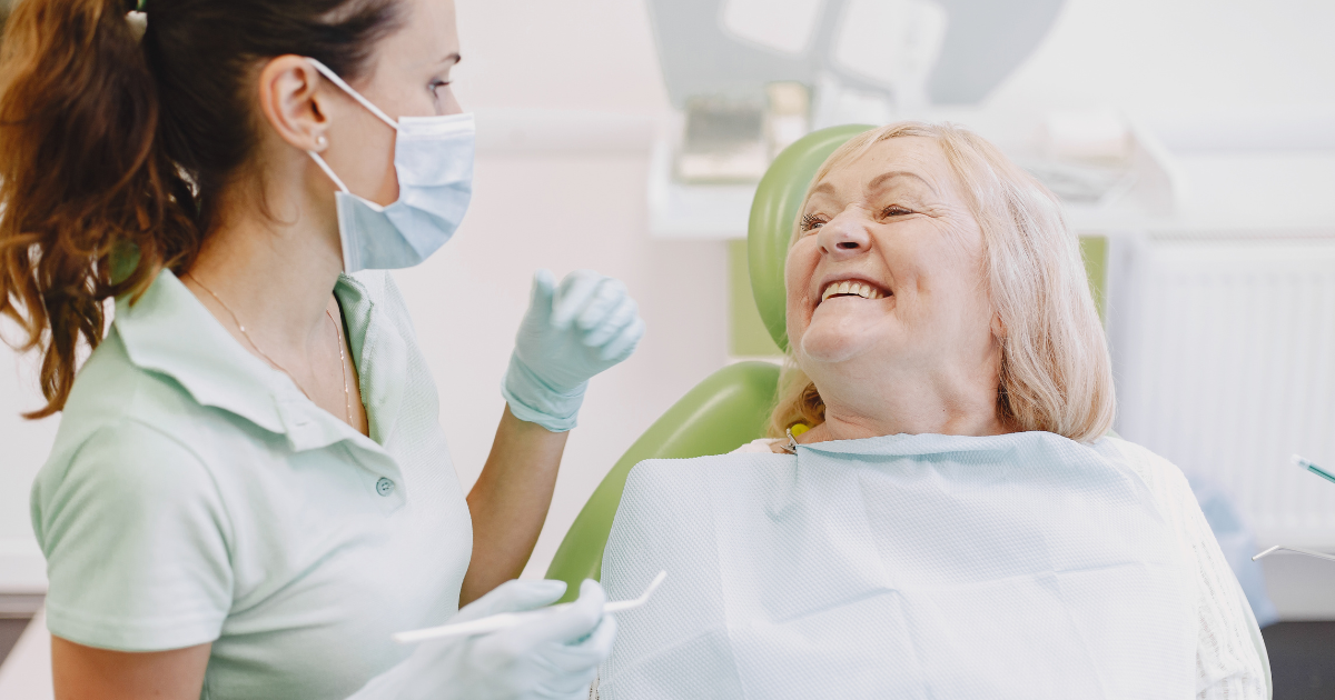 Senior smiling while receiving dental checkup for healthy teeth and gums