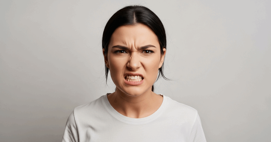 Person clenching jaw with stress, showing effects of tooth grinding (bruxism)