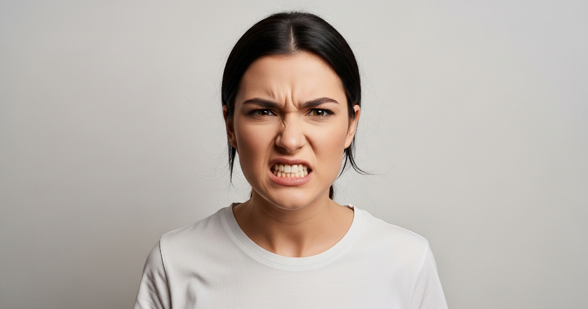 Person clenching jaw with stress, showing effects of tooth grinding (bruxism)